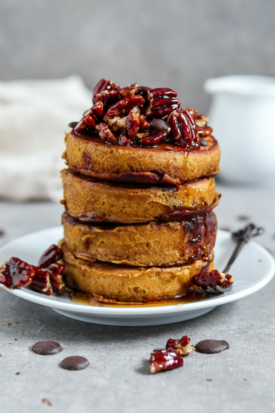 Vegane Pancakes mit Kürbis und Schokoladen-Drops. Dazu gibt es karamellisierte Paranüsse und Ahornsirup.