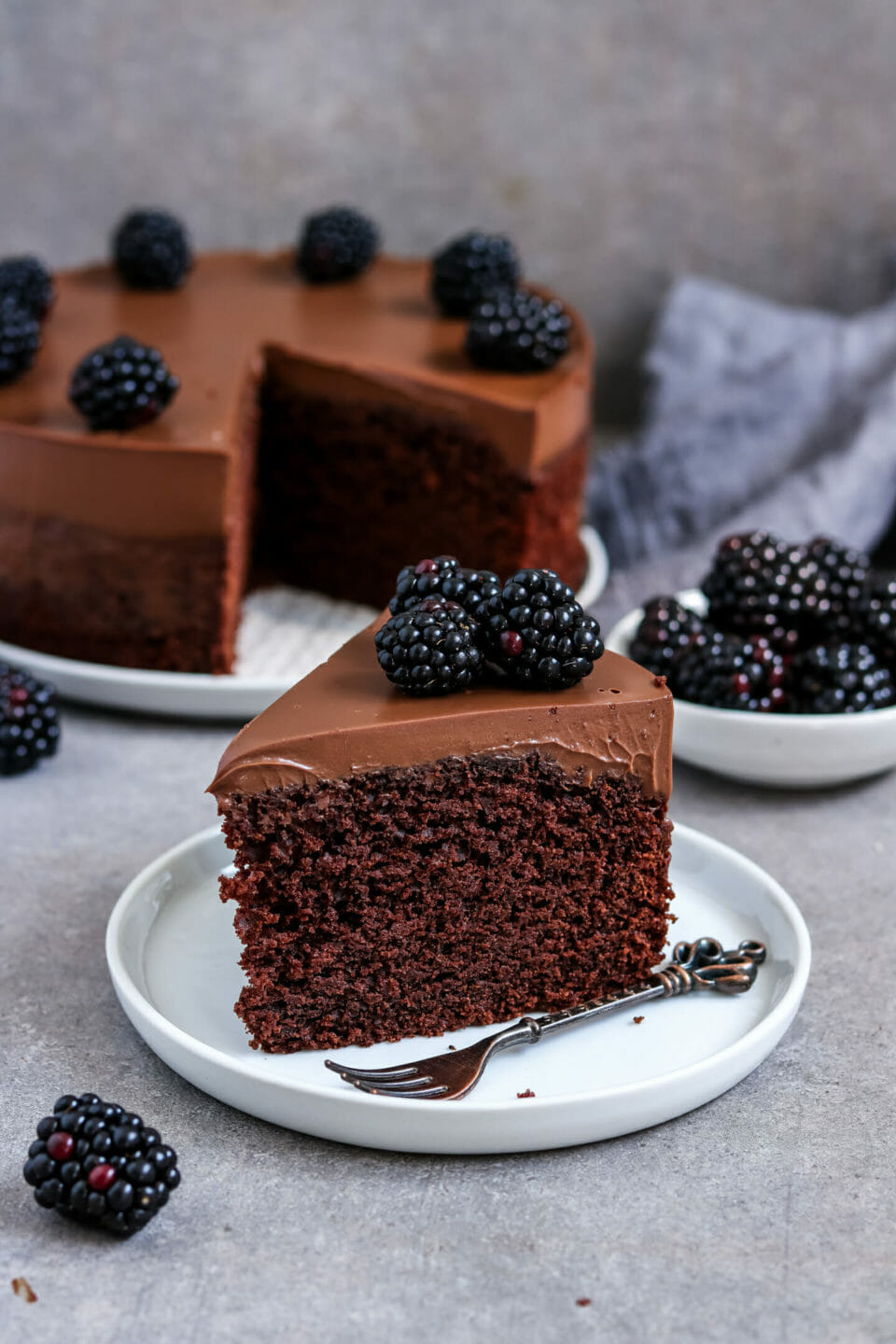 Fluffiger Schokoladenkuchen mit cremigen Schokoladen Frosting und Brombeeren.