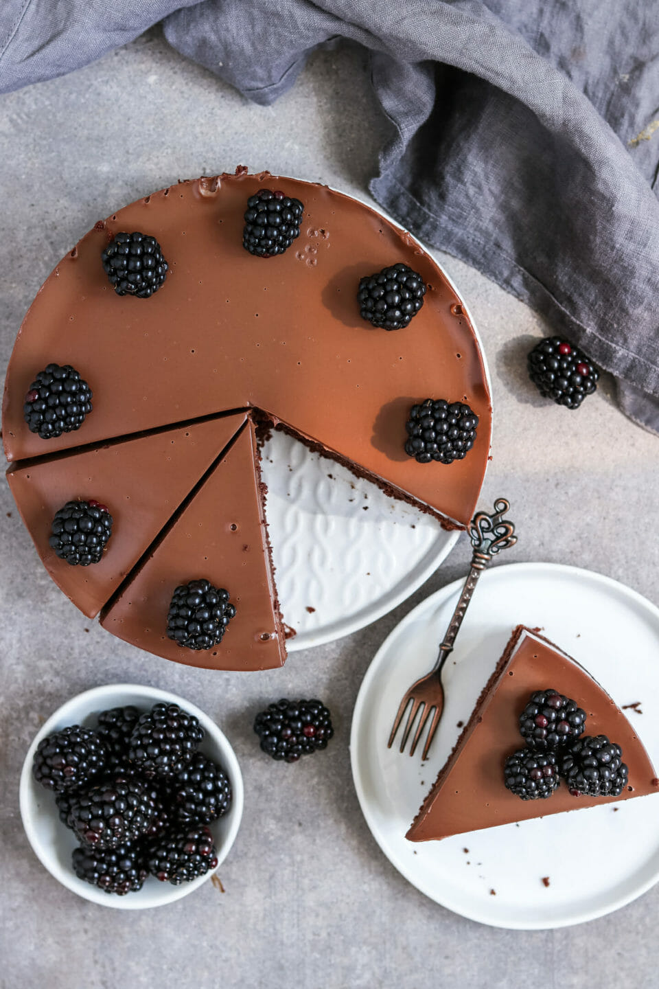 Fluffiger Schokoladenkuchen mit cremigen Schokoladen Frosting und Brombeeren.