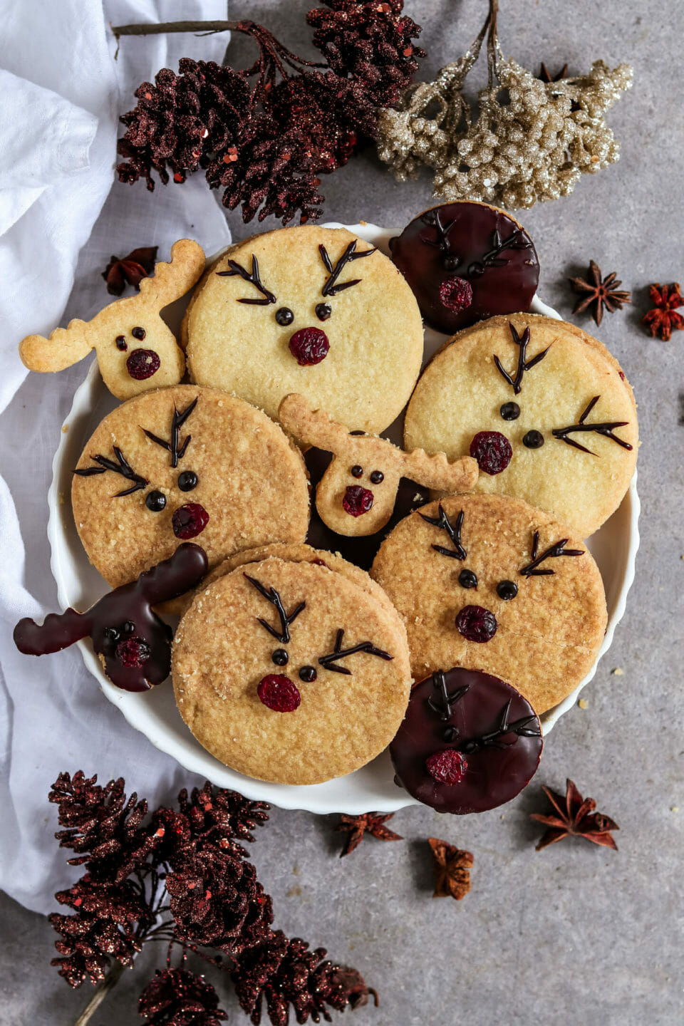 Runde Doppelkekse gefüllt mit einer selbst gemachten Schoko Nuss Creme und dekoriert als Rentiere mit roten Cranberry Nasen.