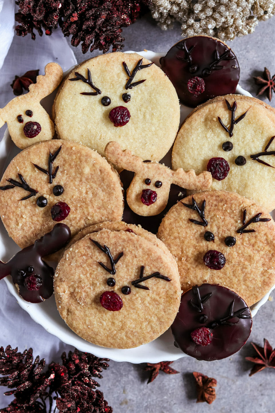 Runde Doppelkekse gefüllt mit einer selbst gemachten Schoko Nuss Creme und dekoriert als Rentiere mit roten Cranberry Nasen.