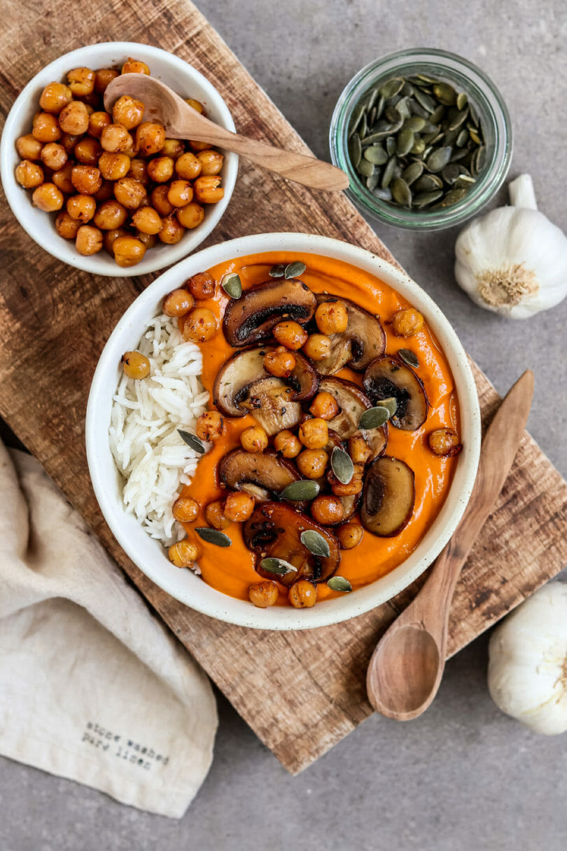 Veganes Garam Masala Curry serviert mit Reis, knusprigen Kichererbsen, Champignons und Kürbiskernen.