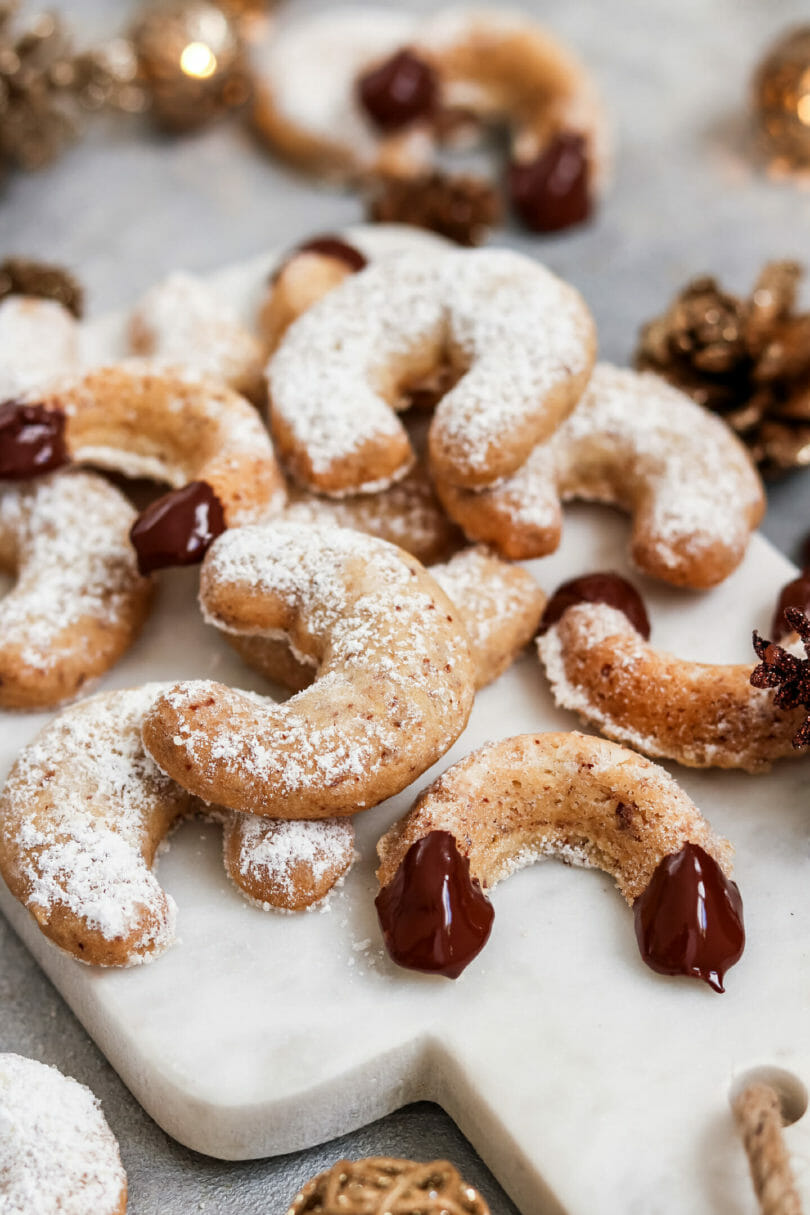 Vegane Vanillekipferl mit Puderzucker und Schokolade.