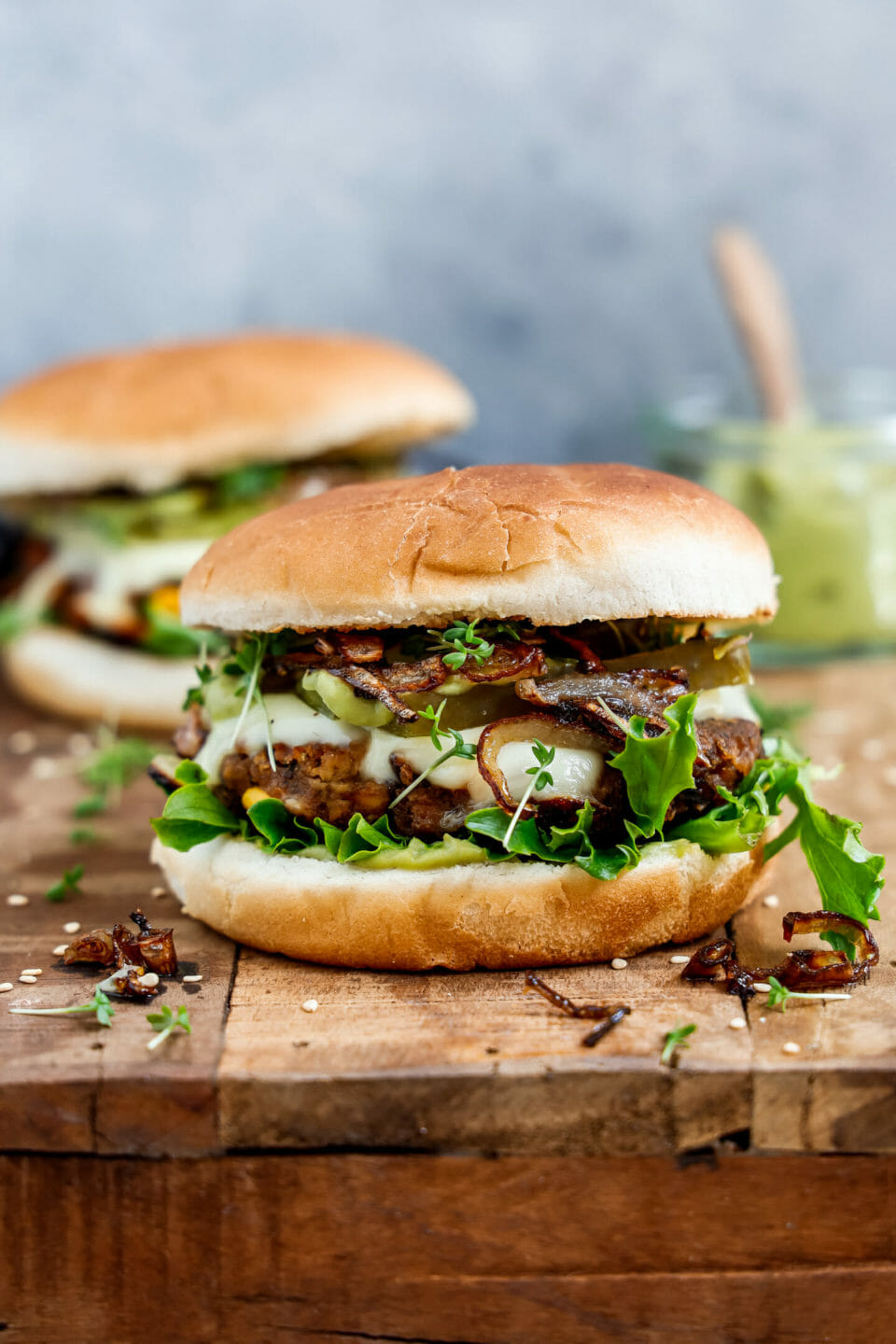 Vegane Burger Patties in einem leckeren Burger serviert auf einem Holzbrett