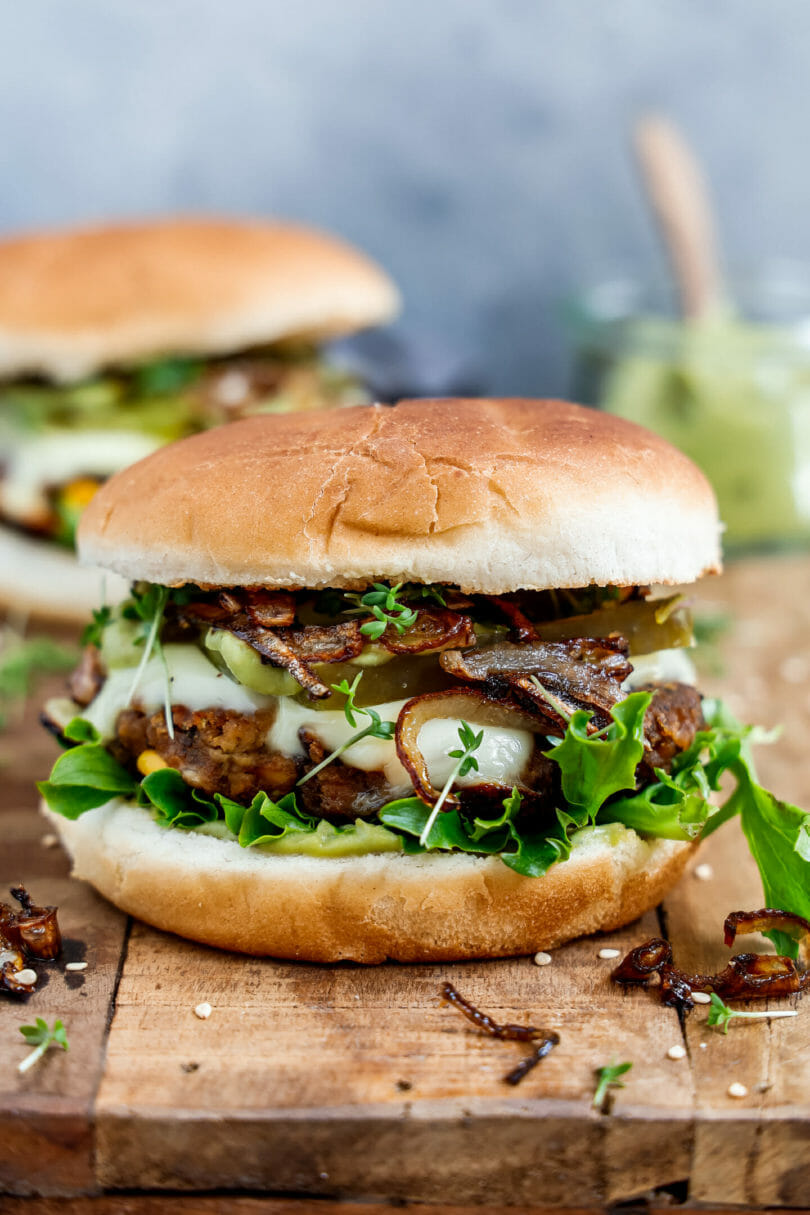 Vegane Burger Patties in einem leckeren Burger serviert auf einem Holzbrett