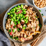 Vegane Thai Nudelpfanne mit Tofu, Gemüse und Erdnusssauce angerichtet in einem tiefen Teller