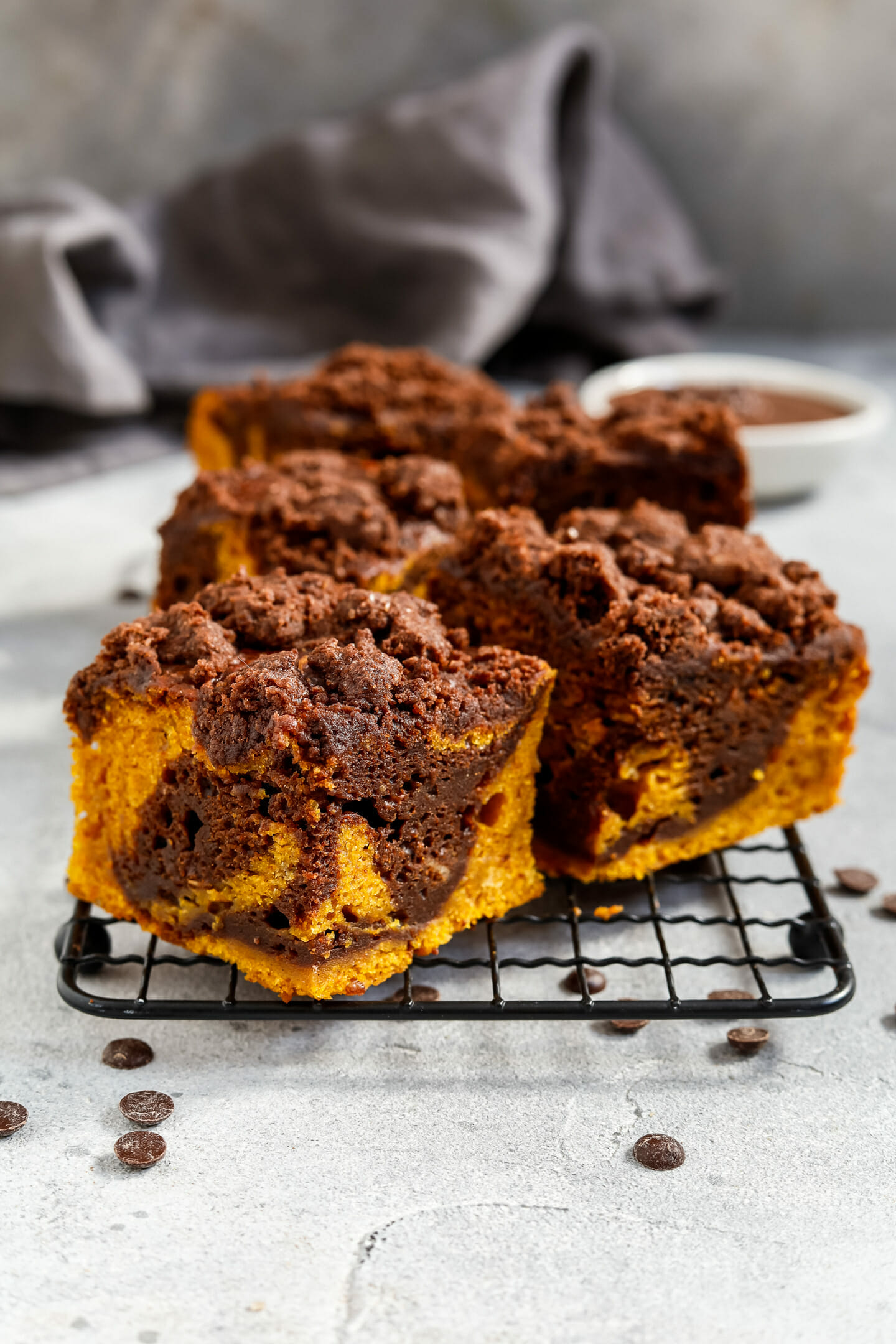 Vegane Kürbis Brownies mit Schoko Zimt Streusel platziert auf einem Abkühlgitter.