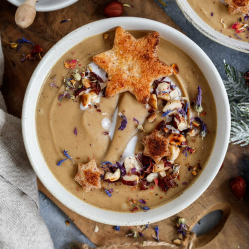 Cremige Maronensuppe mit Zimt-Croûtons weihnachtlich angerichtet und mit geröstetet Haselnüssen sowie Kräutern und Blüten dekoriert