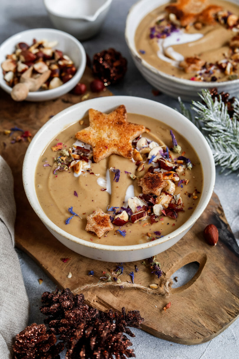 Cremige Maronensuppe mit Zimt-Croûtons weihnachtlich angerichtet und mit geröstetet Haselnüssen sowie Kräutern und Blüten dekoriert