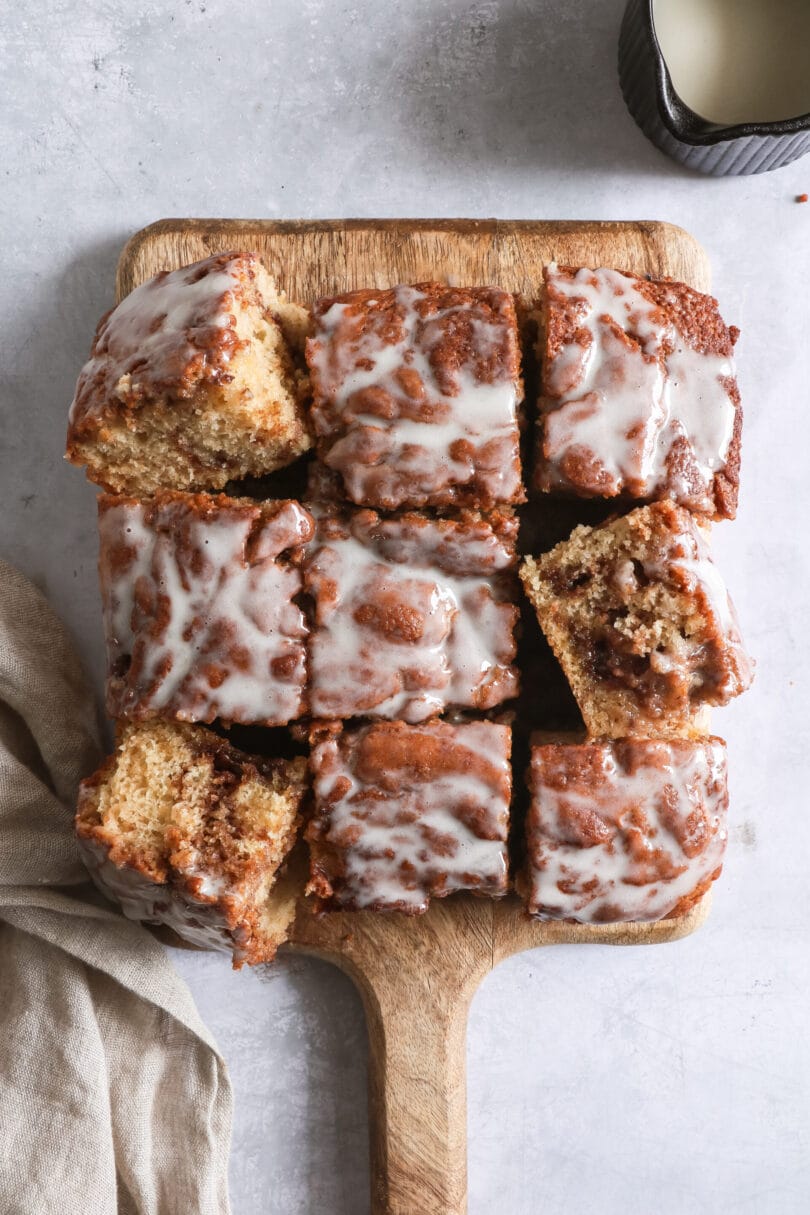 Veganer Zimtschneckenkuchen auf einem Holzbrett vor hellem Hintergrund