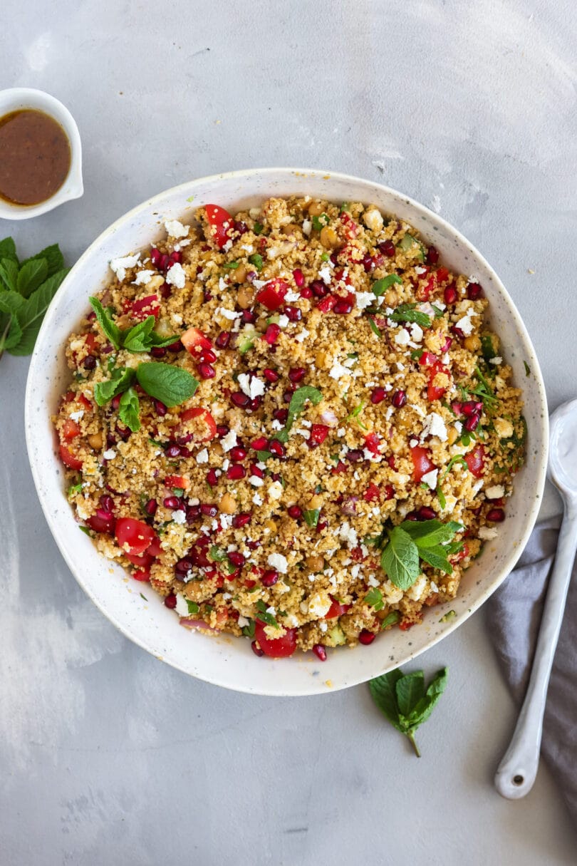 Veganer Couscous-Salat aus der Vogelperspektive mit Granatapfel, Kichererbsen und veganem Feta.