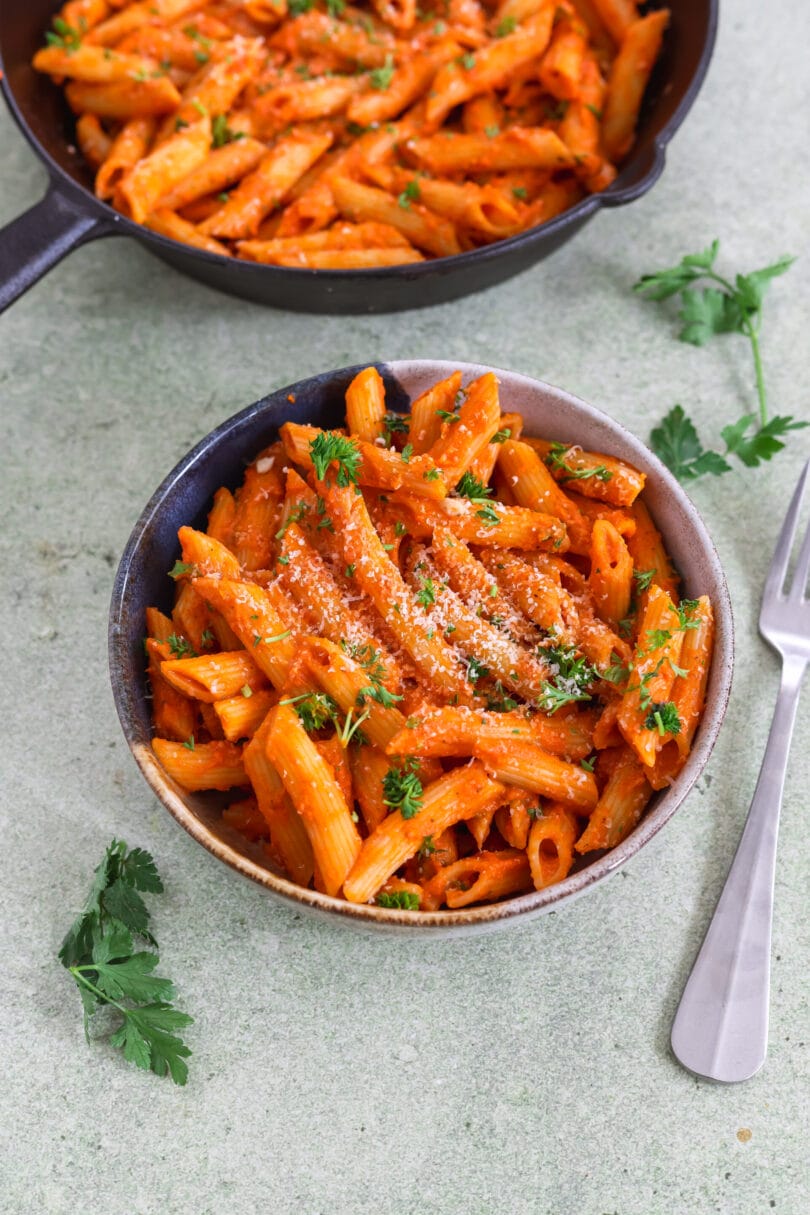 Vegane Penne alla Vodka mit cremiger Tomaten-Vodka-Sauce, veganem Parmesan und frischer Petersilie.